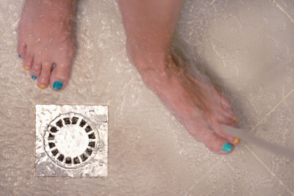 Bare feet with colorful nail polish in the bathroom, floor