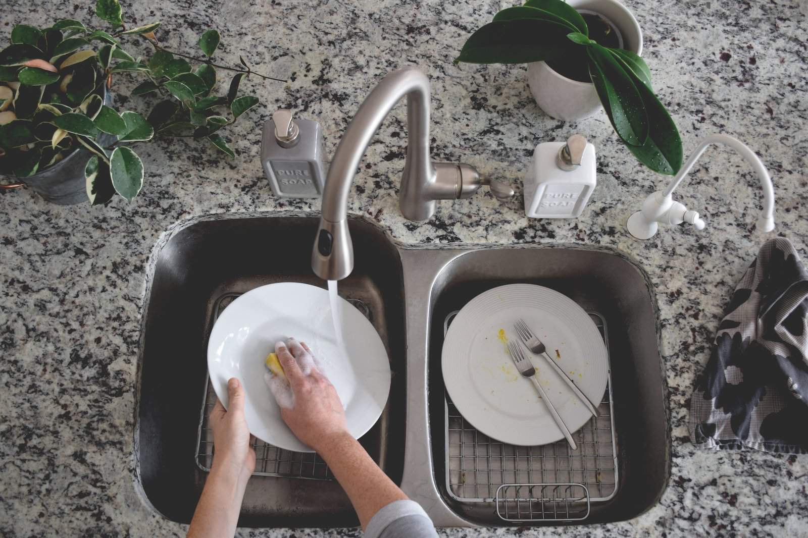 Top view of woman washing dishes in the kitchen sink